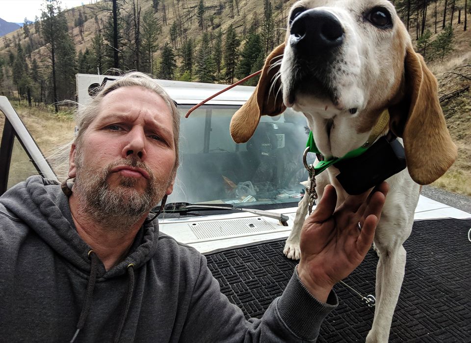 owner with his hound dog taking a selfie in the forest